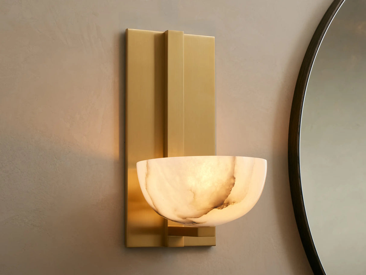 Gold wall sconce with a round mirror on a beige wall